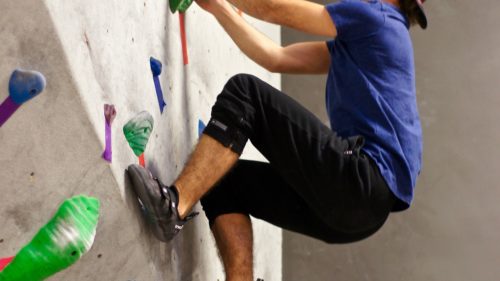 ハーフパンツを履いてボルダリングを行う男性