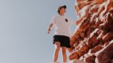 自然岩でボルダリングを行う男性